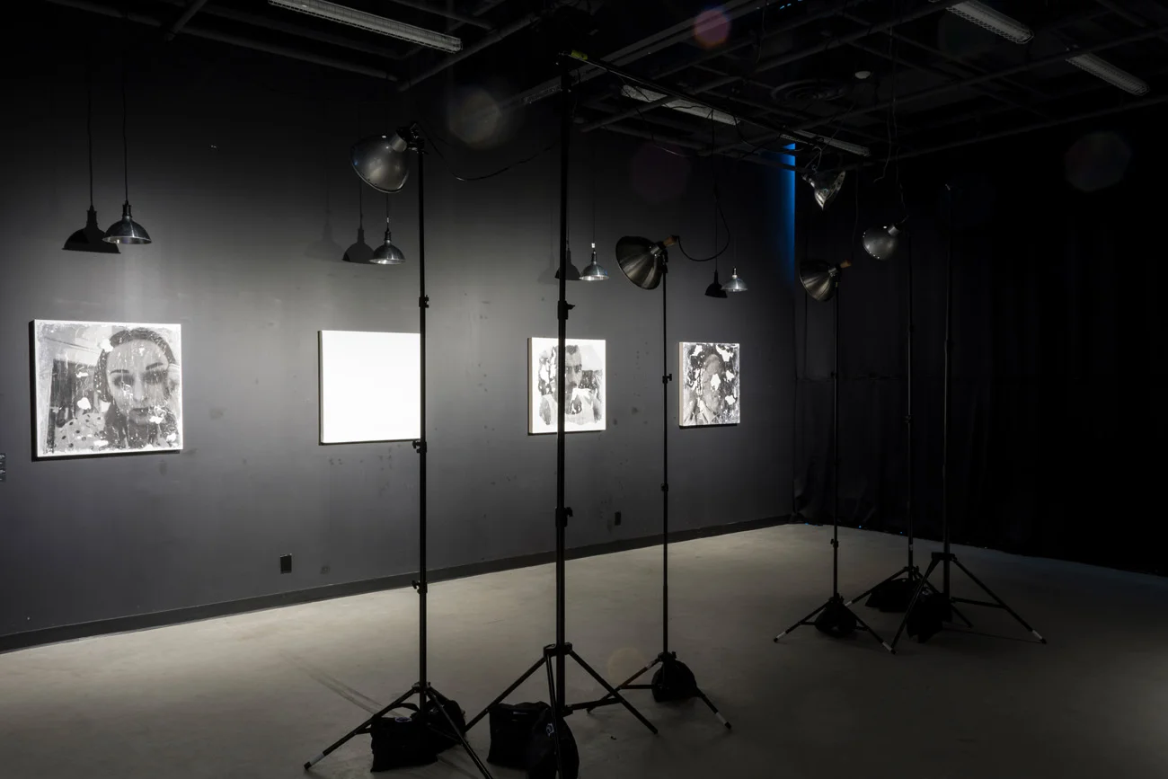 Installation view with paintings and lighting stands