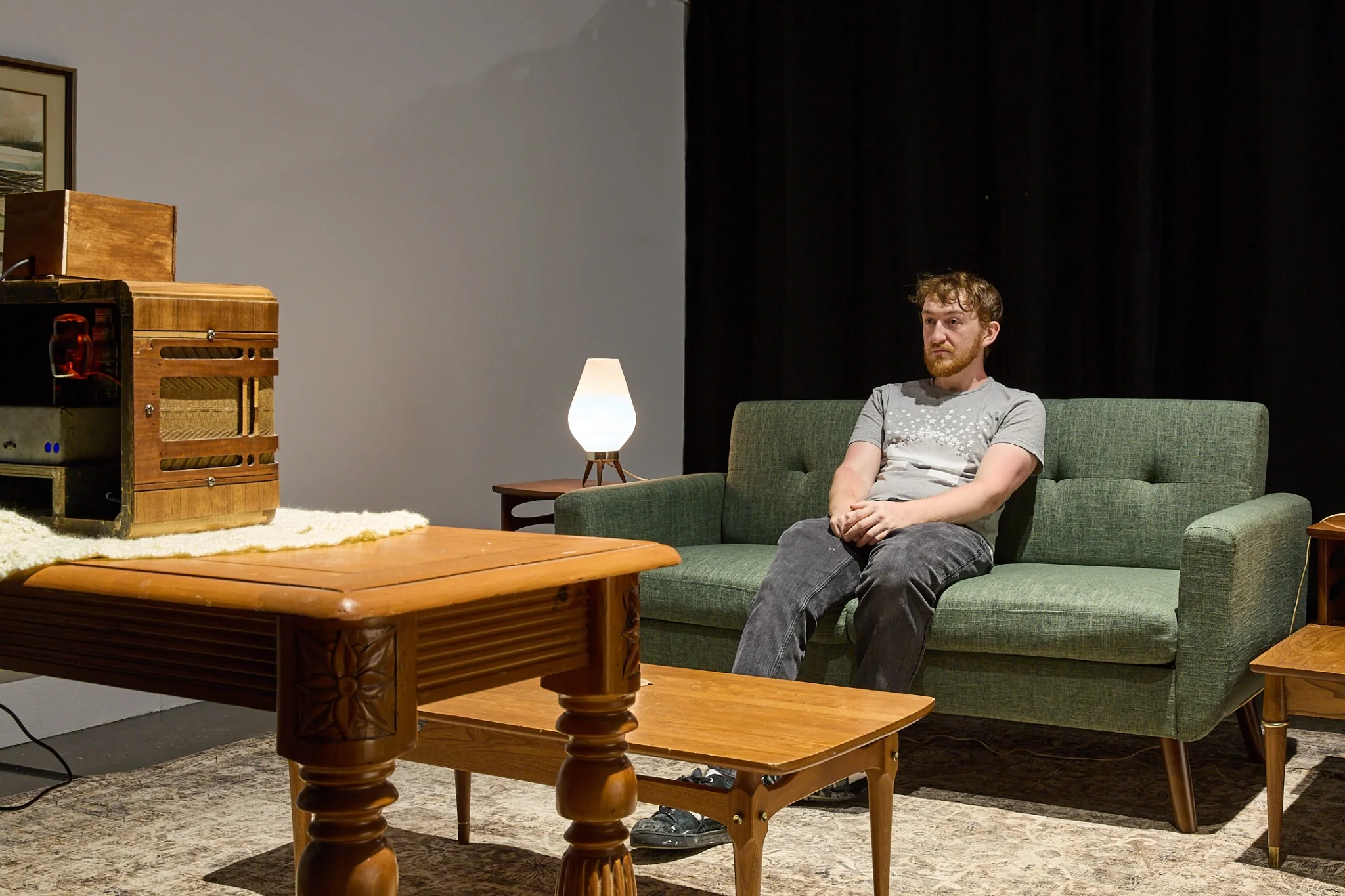 Visitor seated in the living room installation