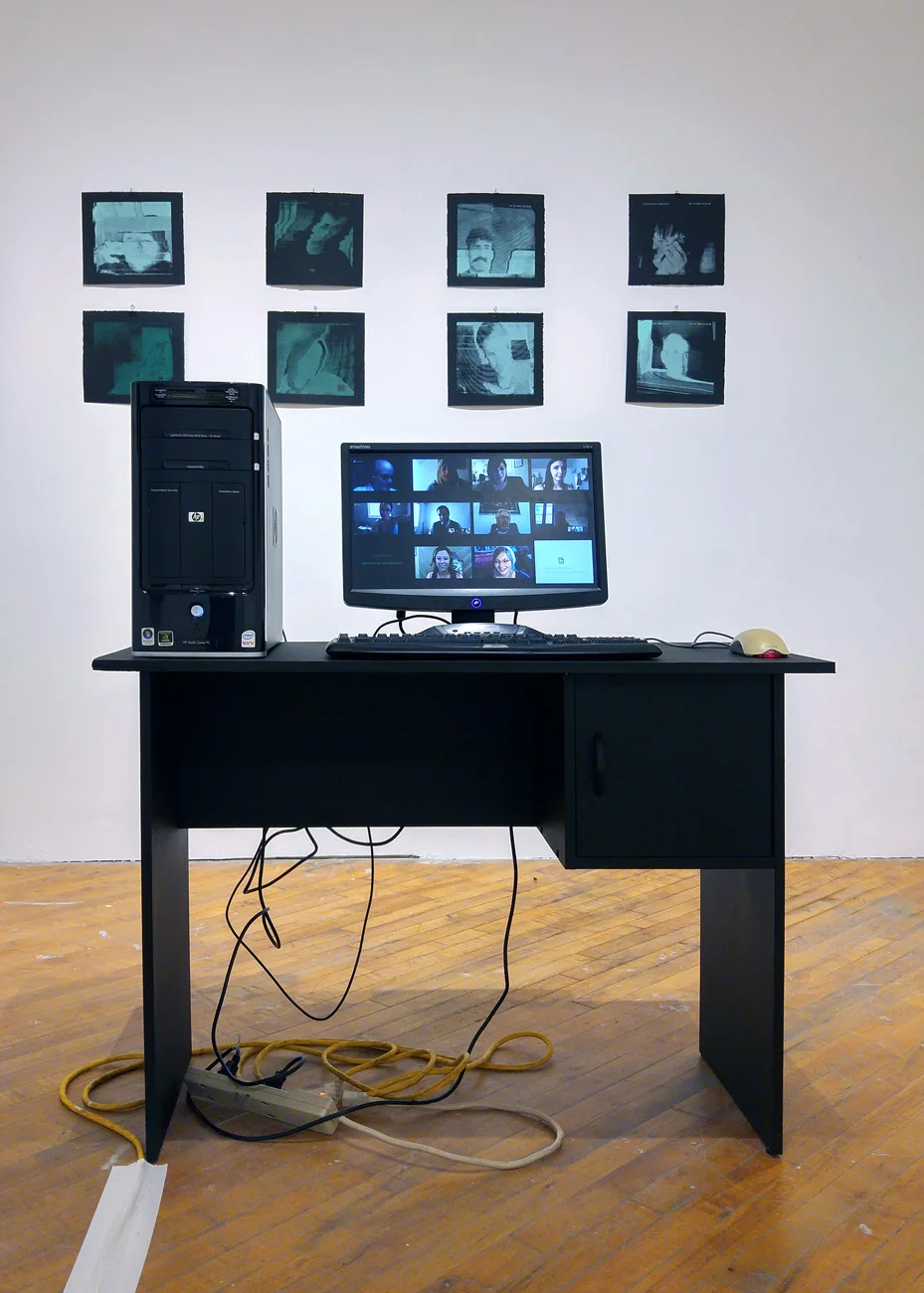 Computer workstation beneath a wall of silkscreen prints